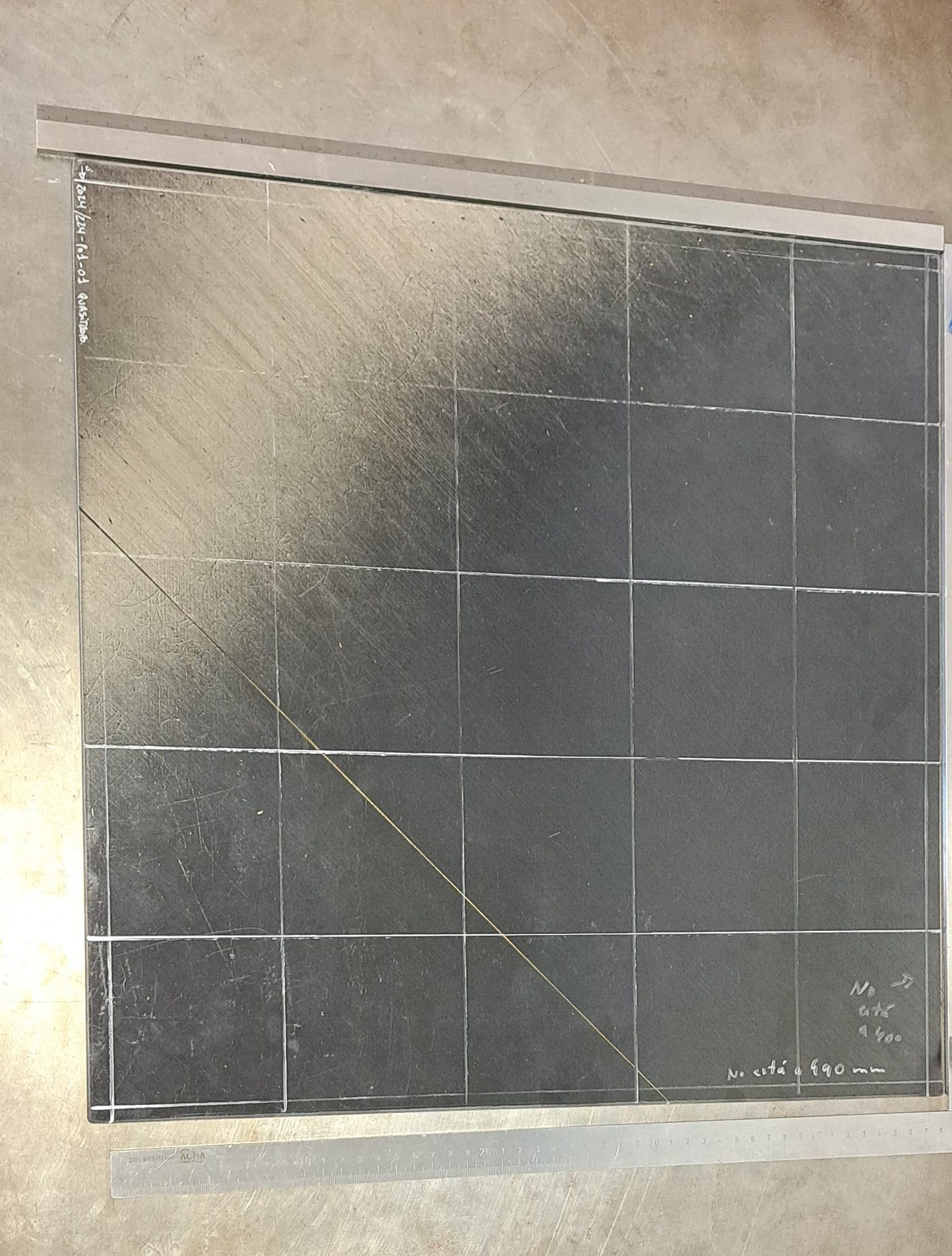 The first manufactured TAC panel, 0.5 by 0.5 meters, shown on a marble surface plate with warpage being measured against a straightedge and ruler